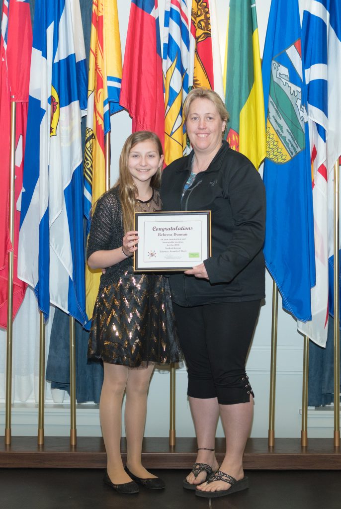 This is a photo of Rebecca Duncan from Estevan, with her honourable mention from the Saskatchewan Literacy Awards of Merit. Rebecca is standing beside her nominator.The following year, the Youth Volunteer Services Award category was created in her honour.