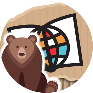 This is a round version of the Saskatchewan Literacy Network logo, designed to connect with the visual style of the book "Fox and Bear" by Miriam Körner, featured in Family Literacy Day 2025. There is a cartoon bear in the lower left, sitting and looking at the viewer. The bear is sitting in front of the stylized book and globe of the Network logo, symbolizing the world of opportunities through literacy. The background looks like torn cardboard, to look like the repurposed materials used in the book art.